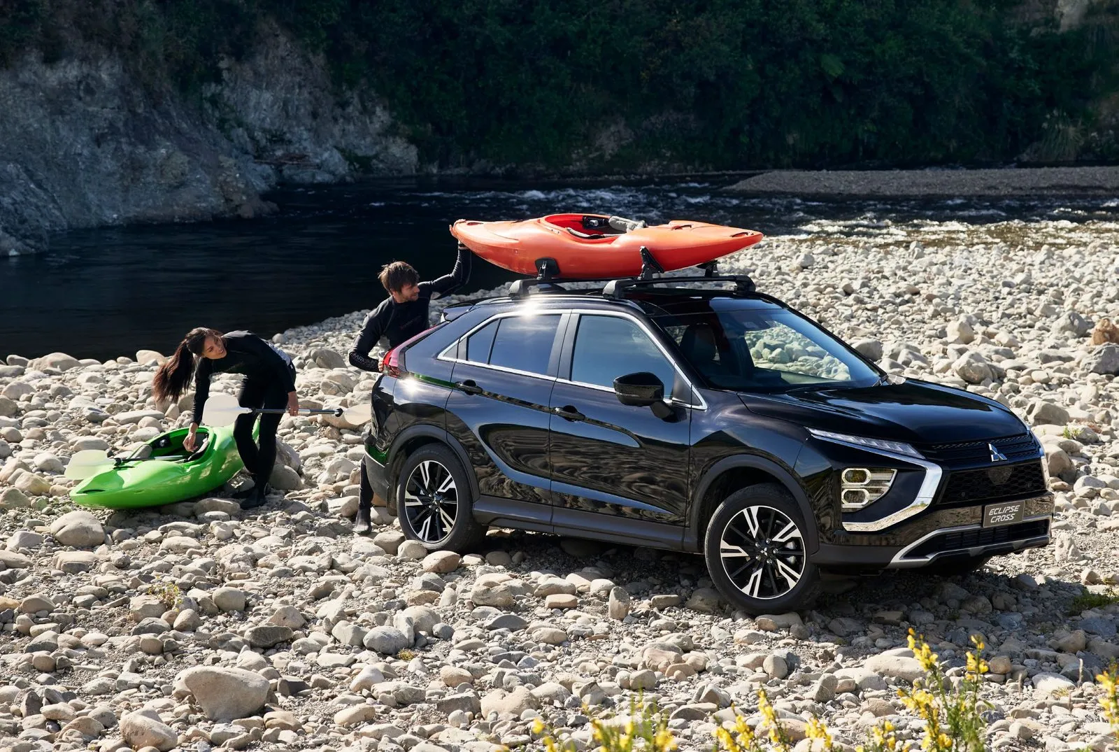 Loading kayaks onto a black Mitsubishi Eclipse Cross at a river