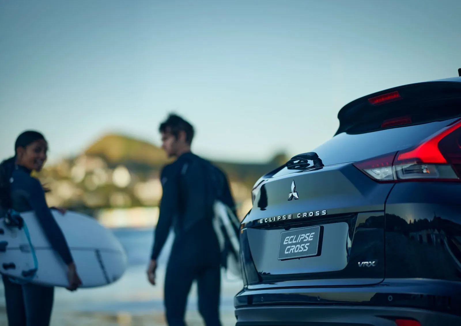 Mitsubishi Eclipse Cross parked at the beach with surfers