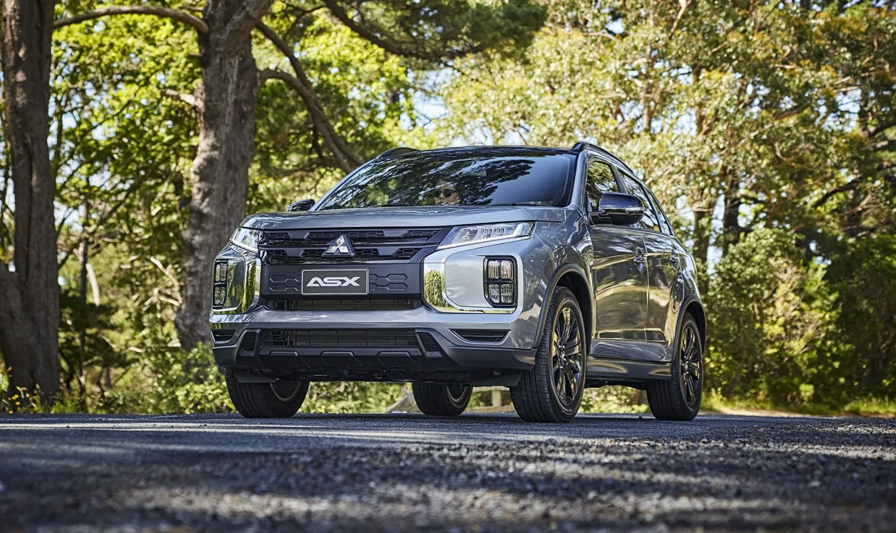 Mitsubishi ASX driving on a tree-lined road