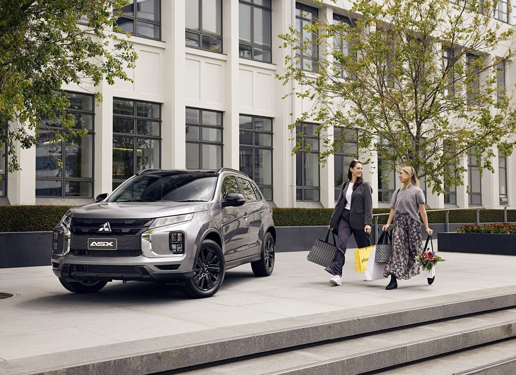 Silver Mitsubishi ASX parked outside a modern city building