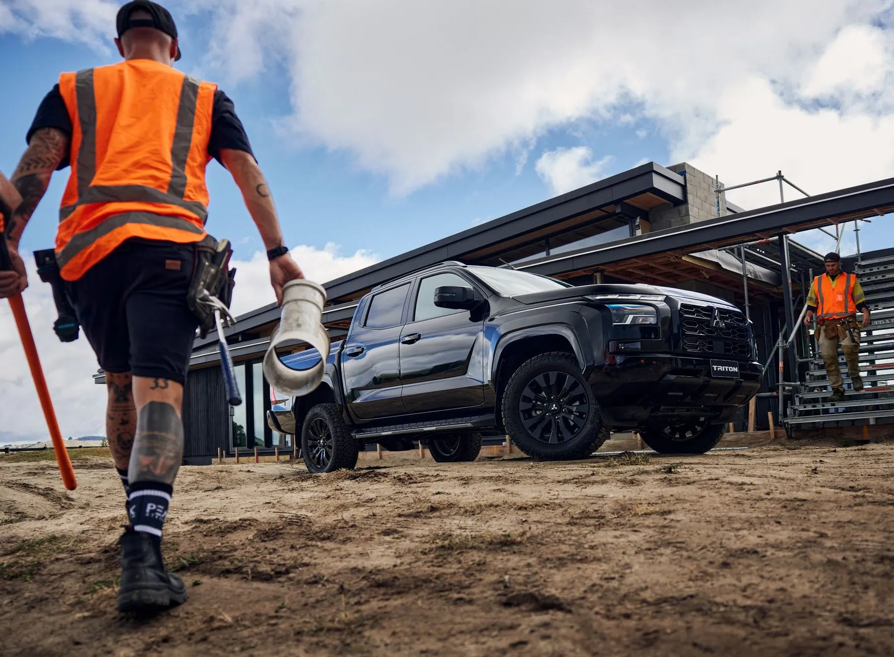 Tradesperson walking towards a Triton on a work site